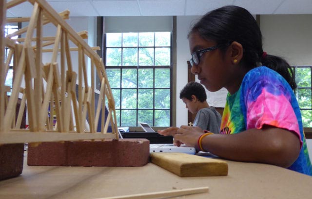 Girl at computer with truss bridge